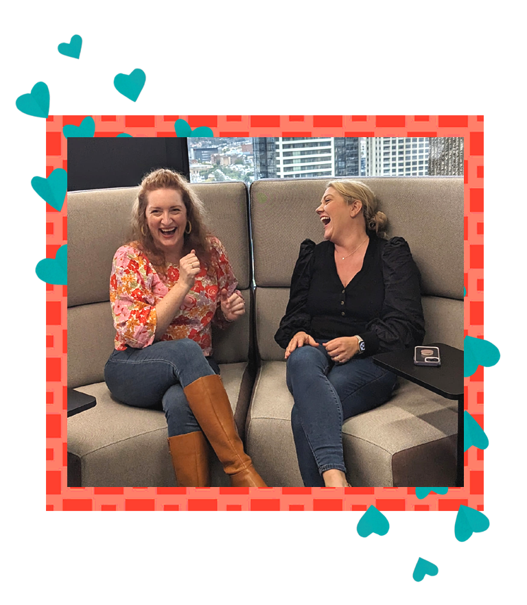 Ally & Clare sitting on a couch laughing together.